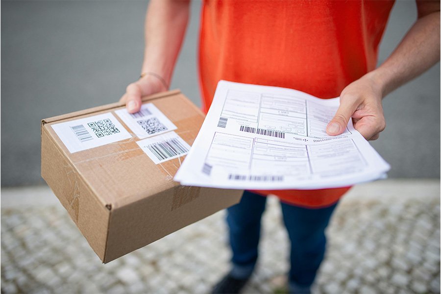 Person holding a cardboard parcel and shipping documents, illustrating Aus City Movers' reliable parcel delivery