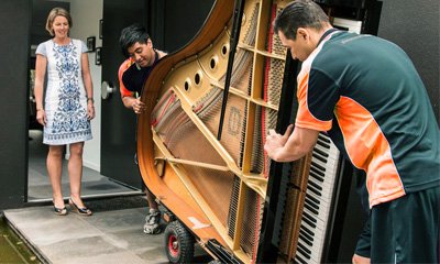 Aus City Movers team carefully moving a grand piano, specialized piano relocation services.