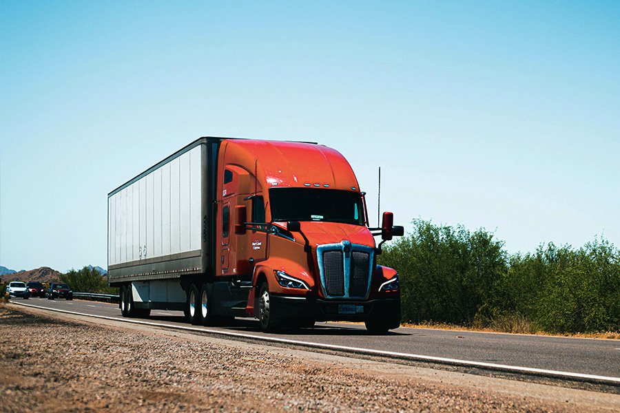 Red moving truck on highway, symbolizing Aus City Movers' interstate moving services across Australia, emphasizing